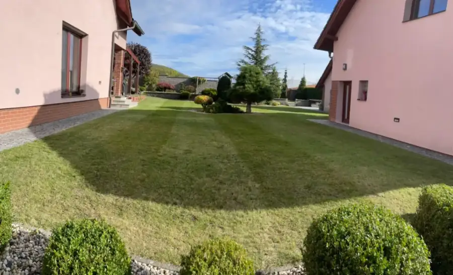 Pravidelně sekaný a udržovaný trávník mezi rodinnými domy, Beroun