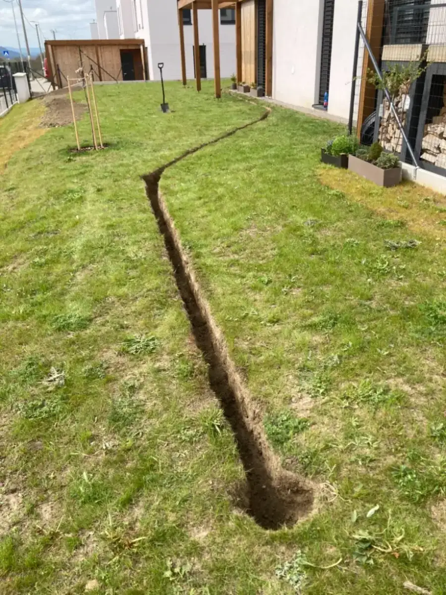 Výkop rýhy pro rozvody závlahového systému v trávníku